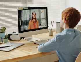 photo of child sitting by the table while looking at the imac